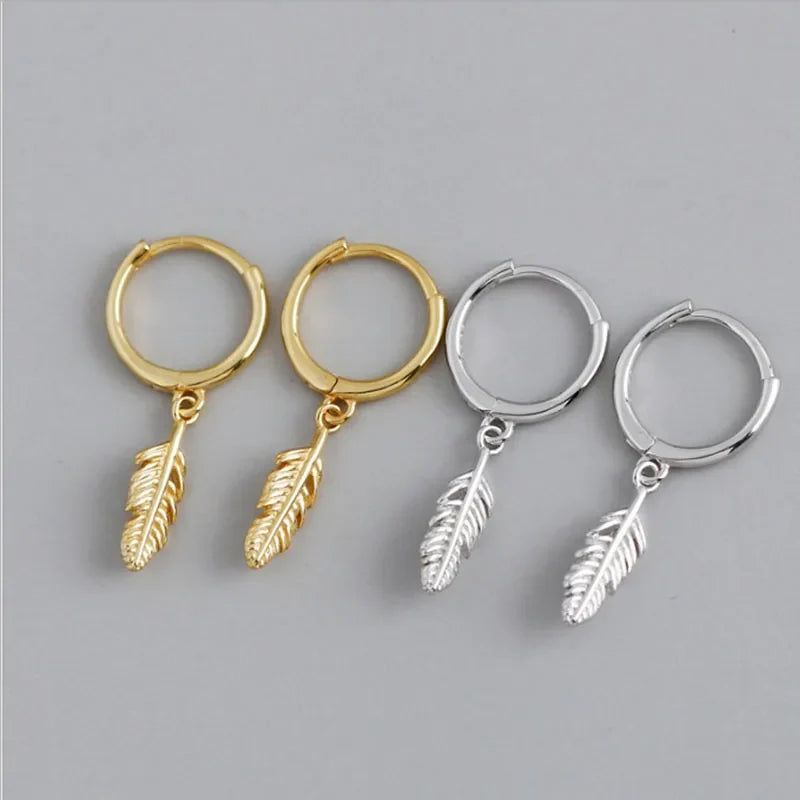 Gold hoop earrings with small dangling feather