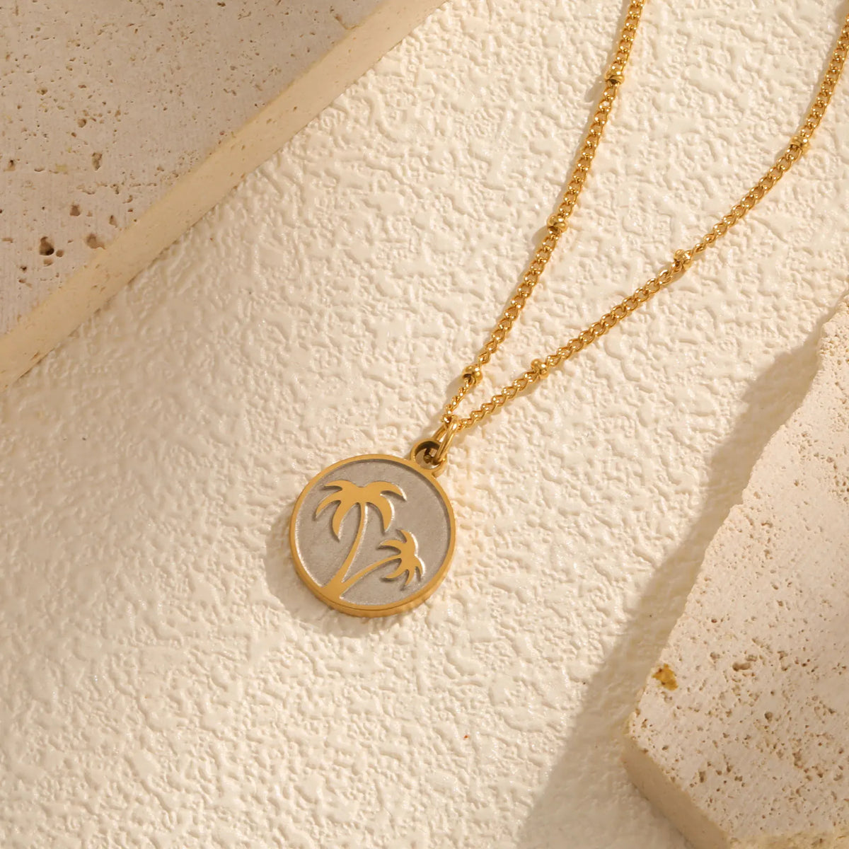 Necklace with round pendant and palm tree motif