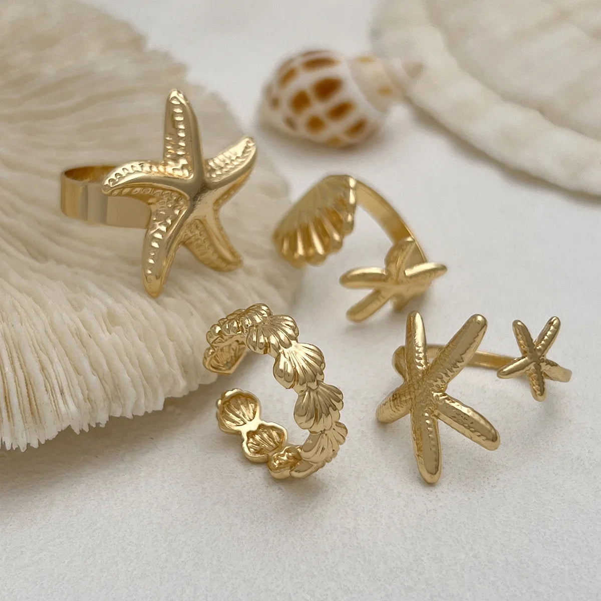 Set of 4 shell and starfish rings in gold